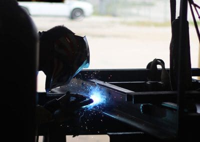 A man welding metal in our custom metal fabrication and welding shop