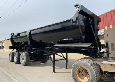 A semi truck trailer dump truck painted with an industrial black paint to match the fleet.